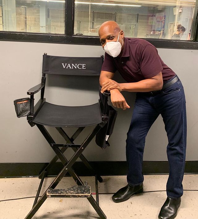 Daryl Edwards in a white mask, maroon shirt and blue jeans.